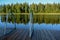 Peaceful summer afternoon on a beautiful and clean lake. Steel ladders and wooden platform for a refreshing jump