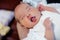 Peaceful sweet newborn infant baby lying on bed while sleeping in a bright room