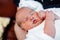 Peaceful sweet newborn infant baby lying on bed while sleeping in a bright room