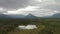 Peaceful View of Pond and Marshland surrounded by Forest and Mountains