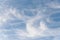 Peaceful wispy white clouds against a clean blue sky as a nature background