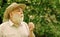 Peacefulness. Tranquility and serenity. Happy and carefree retirement. Lonely grandpa blowing dandelion seeds in park