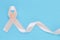 Peach color ribbon curl on pastel blue isolated background with copy space, symbol for Uterine and Endometrial cancer awareness,