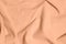 Peach fuzz, color of the year 2024, velvety fabric texture. Texture of velvet textile toned on peach fuzz color.