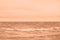 Peach fuzz toned sea beach. North sea. Stormy weather: strong waves, gloomy sky, sea foam. Trendy colour 2024.