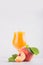 Peach juice in elegance glass with juicy piece peaches on light white wood table, copy space, vertical, closeup.