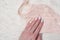Peach lace bodice in female hand. Gentle manicure. Close-up