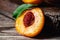 Peach with leaf on wooden table. Peach in half. Ripe juicy peaches. Harvest of peaches for food or juice. Closeup