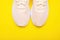 Peach sneakers on yellow background. Concept of healthy lifestile, everyday training and yoga.