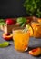 Peach tea with ice and rosemary on a glass. Vegan homemade healthy drink on a dark background with fresh fruits