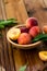 Peaches with leaves in a wooden bowl with peach in halves on top. Flat lay composition with ripe juicy peaches. Harvest of peaches