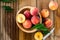 Peaches with leaves in a wooden bowl with peach in halves on top. Flat lay composition with ripe juicy peaches. Harvest of peaches