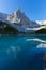 Peak of Dito di Dio mountain reflected in green water of lake Sorapis