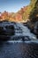 Peak fall foliage surrounds beautiful cascading lower Shohola Falls