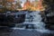 Peak fall foliage surrounds beautiful cascading lower Shohola Falls