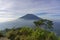 The peak of Mount Merbabu as seen from Mount Telomoyo with vegetation and trees as the foreground