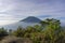The peak of Mount Merbabu as seen from Mount Telomoyo with vegetation and trees as the foreground