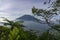 The peak of Mount Merbabu as seen from Mount Telomoyo with vegetation and trees as the foreground