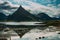 Peak mountain with reflection, bridge on the background, Lofoten Islands