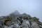 peak of Rysy mountain covered in mist. autumn ascent on hiking t
