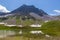 peak of Valbellahorn, lake of Altein, blue sky, green grassland, snow