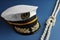 Peaked cap with accessories and rope on blue background