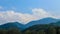 The peaks of the mountains of the Trans-Ili Alatau on a summer day, over which picturesque clouds float.