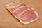 Peameal bacon on wood cutting board