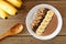 Peanut-butter, banana, chocolate smoothie bowl on rustic wood