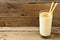 Peanut-butter banana oat smoothie with straws over rustic wood