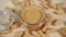 Peanut butter in a glass jar with a metal fastener on a wooden table close-up with a bunch of nuts