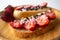 Peanut butter spread toasts with chocolate chips, strawberries, coconut flakes and homemade bread