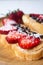 Peanut butter spread toasts with chocolate chips, strawberries, coconut flakes and homemade bread