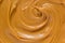 Peanut butter texture background. Creamy smooth brown nut spread swirl