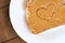 Peanut butter toast with heart shape on white against wood