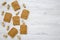 Peanut butter toasts and unshelled peanuts on a white wooden background, top view. Copy space.