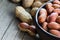 Peanut in nutshell in burlap sack or sackcloth and bowl on wooden background. Composition of peanuts