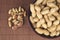 Peanuts in a ceramic bowl on a wooden background