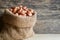 Peanuts in hemp sack on wooden background