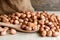 Peanuts in hemp sack on wooden background