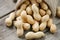 Peanuts in a miniature burlap bag on old, gray wooden surface