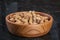 Peanuts in nutshell on a piece of wood and peeled peanuts in golden bowl on sackcloth.