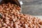 Peanuts in stainless cup on wooden background.