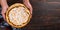 Pear pie with cream in female hands, homemade pastries on wooden table, with spices. Copy space