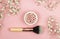 Pearl make up powder and brush for powder on pale pink background