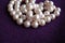 Pearl necklace piled on purple cashmere background