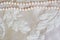 Pearl necklace on satin fabric texture background with space for