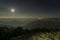 Pearls of light of Queen of Hills, Darjeeling town, at night at far right. Full moon on the night sky shows of mountains of