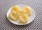 Pears halves on a white plate atop tablecloth