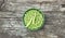 Peas in a bowl with fresh cut plant leaf nearby and bean pods on wooden rustic textured background